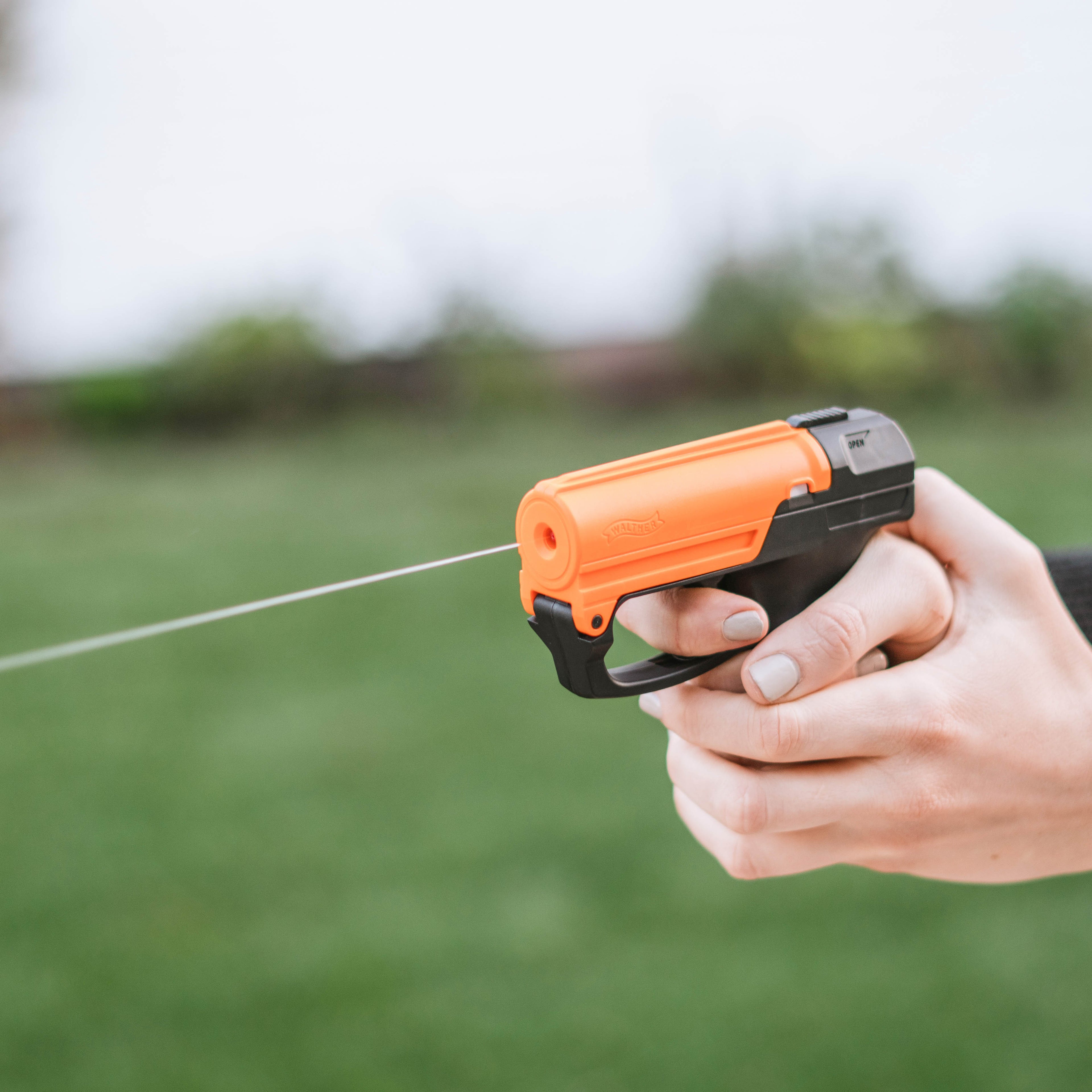 SABRE Aim and Fire Pepper Gel in hand demonstrating grip safety and trigger deployment – easy-aim non-lethal pepper gel pistol for self-defense